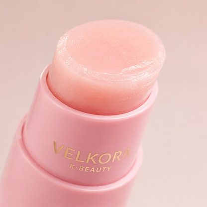 Primer plano del bálsamo Velkora PDRN: textura rosa cremosa en la punta del stick
